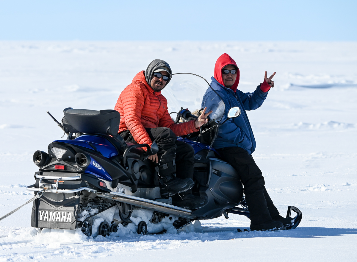 Inuit guides on snowmobile